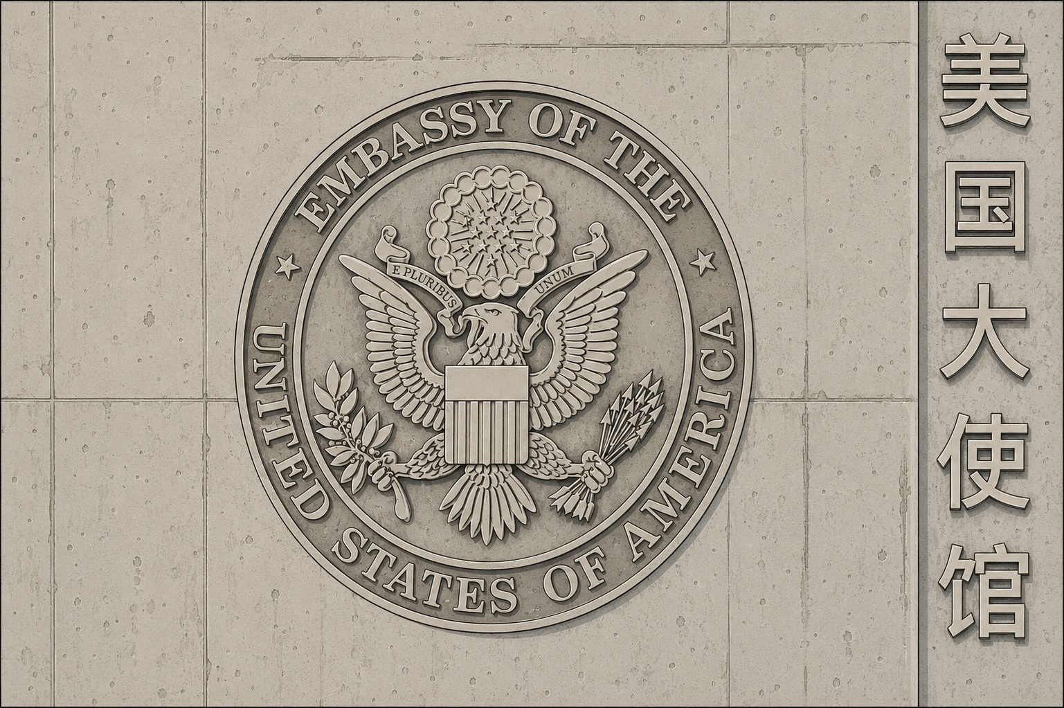 Seal of the Embassy of the United States of America on a stone wall, with Chinese characters to the right.